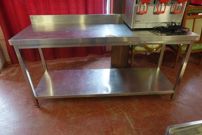 une table de travail en acier inoxydable sur laquelle est posé un micro-ondes