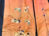 a close up of an orange and blue dress with flowers on it