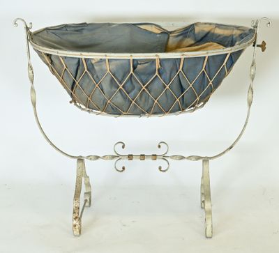 a baby basket with a blanket in it on a stand