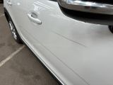 a white car parked in a parking lot next to other cars