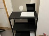 an image of a small room with a desk and shelves