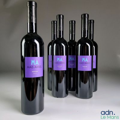 trois bouteilles de vin rouge sont alignées sur une table