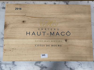 une boîte en bois sur laquelle est apposée une étiquette portant l'inscription « Château Haut - Maco »