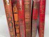several red books are lined up in a row on a white surface