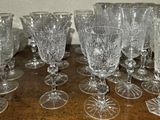 a lot of wine glasses sitting on a wooden table