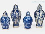 quatre vases bleus et blancs sont alignés sur un fond blanc