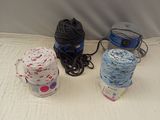 three balls of yarn sitting on a bed next to each other