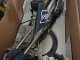 une boîte en carton posée par terre, contenant des outils