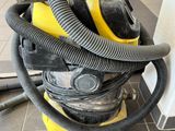 a yellow and black vacuum sitting on a tile floor
