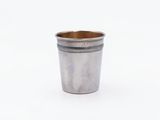 a silver cup that is sitting on a white surface