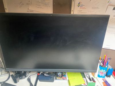 un écran d'ordinateur posé sur un bureau à côté d'un clavier