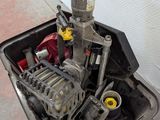 a small engine sitting in a metal container on the floor