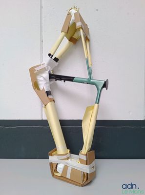 une sculpture en carton représentant un homme avec une canne et une boîte