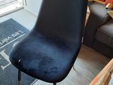 a black chair sitting in a living room next to a window