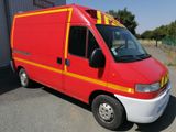 a red van with yellow stripes parked in a parking lot