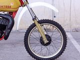 a red and yellow dirt bike parked in a parking lot