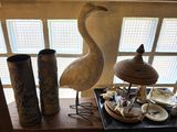 a bird that is standing on a table next to some vases