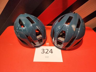 pair of blue bicycle helmets on a red table with a price tag