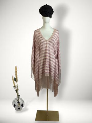 the sweater is pink and white with fringes on a mannequin stand
