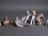 Plusieurs figurines représentant des animaux et des oiseaux sont posées sur une table