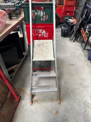 a ladder that is sitting in a room with many other items