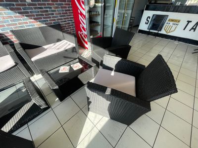 une chaise en osier noir et une table blanche dans une pièce