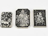 three silver metal objects on a white surface with a white background