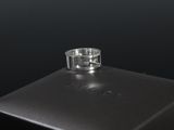gros plan d'une bague en argent sur une surface noire