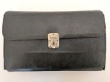 black leather briefcase sitting on top of a white surface