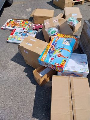 de nombreuses boîtes de jouets posées par terre à côté d'une voiture