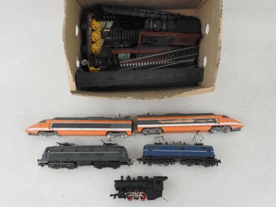 quatre petits trains miniatures posés dans une boîte sur une table
