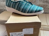 pair of blue and white striped shoes sitting on top of a cardboard box