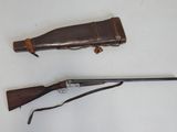 rifle and shotgun on a white surface with a leather case