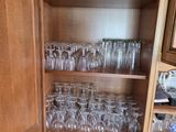 a cabinet with many glasses and plates in it
