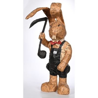 une image représentant une sculpture en bois d'un lapin tenant une pipe à la main