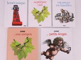 four books on a white table with a red object in the middle of them