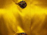 a close up of a yellow jacket with buttons on it
