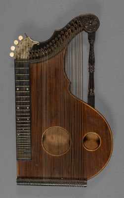 un vieil instrument de musique avec un corps en bois et des cordes, sur fond gris