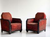 pair of red upholstered chairs in a white room
