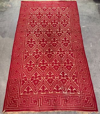 a red and white rug with a pattern on it