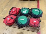 several red and green gas cans sitting on top of a wooden pallet