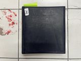 a black binder on the floor next to a yellow post - it