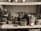 de nombreuses casseroles et poêles sur les étagères de la cuisine