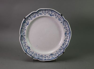 blue and white plate with a floral design on the rim