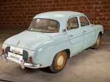 a small blue car parked in front of a brick wall
