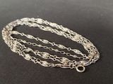 a close up of a silver chain bracelet on a black surface