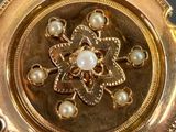 a close up of a gold plate with pearls on it