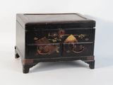 une petite boîte noire décorée de fleurs et d'oiseaux