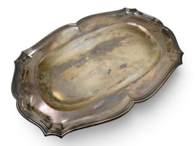 an antique silver plate with a decorative edge on a white surface