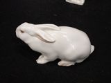 a white rabbit figurine sitting on a black surface